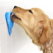 Golden retriever licking peanut butter off a blue lickimat suctioned to a white tile wall 
